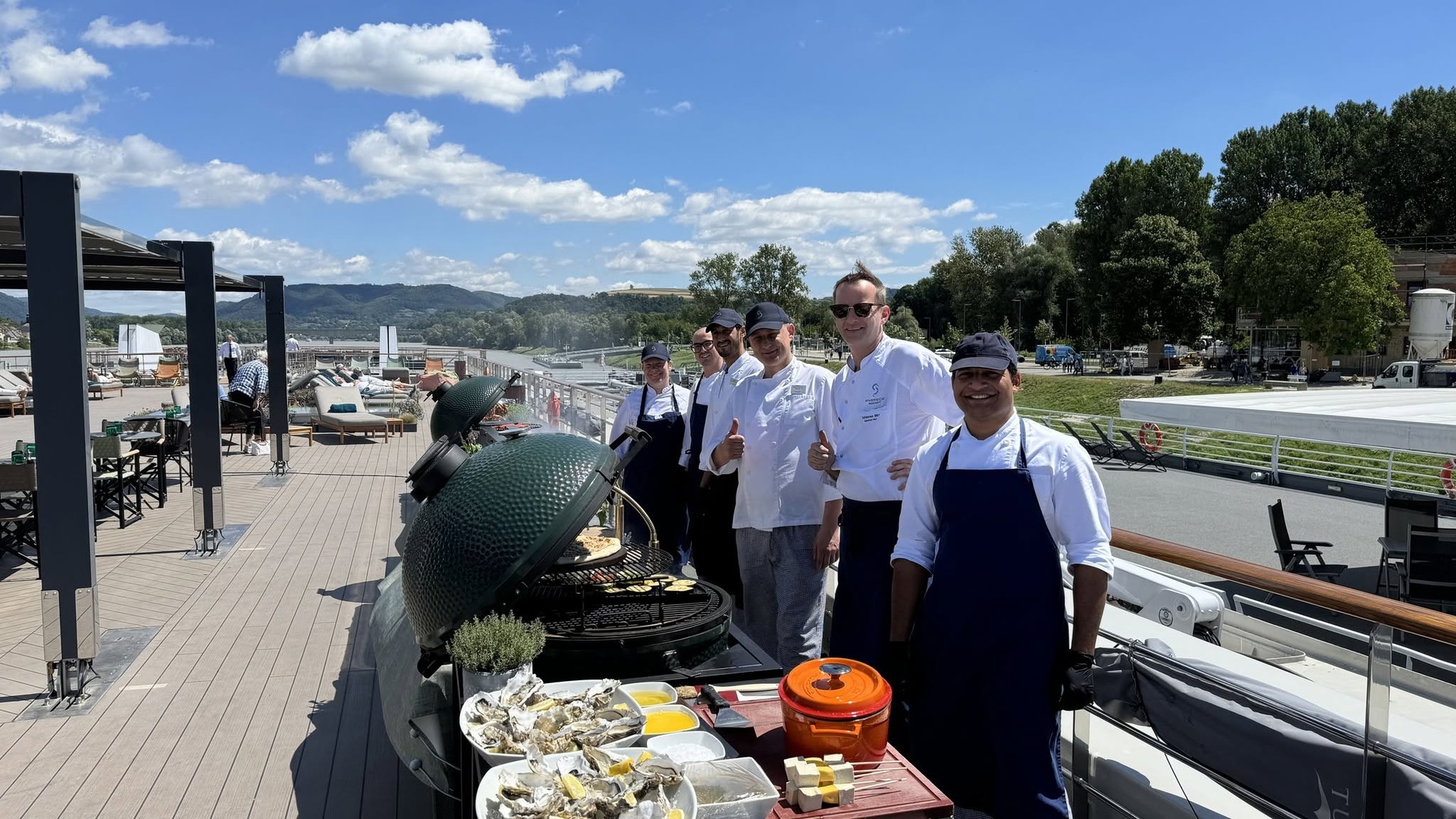 Riverside executive chefs standing by the sun deck barbecue smoker and grill