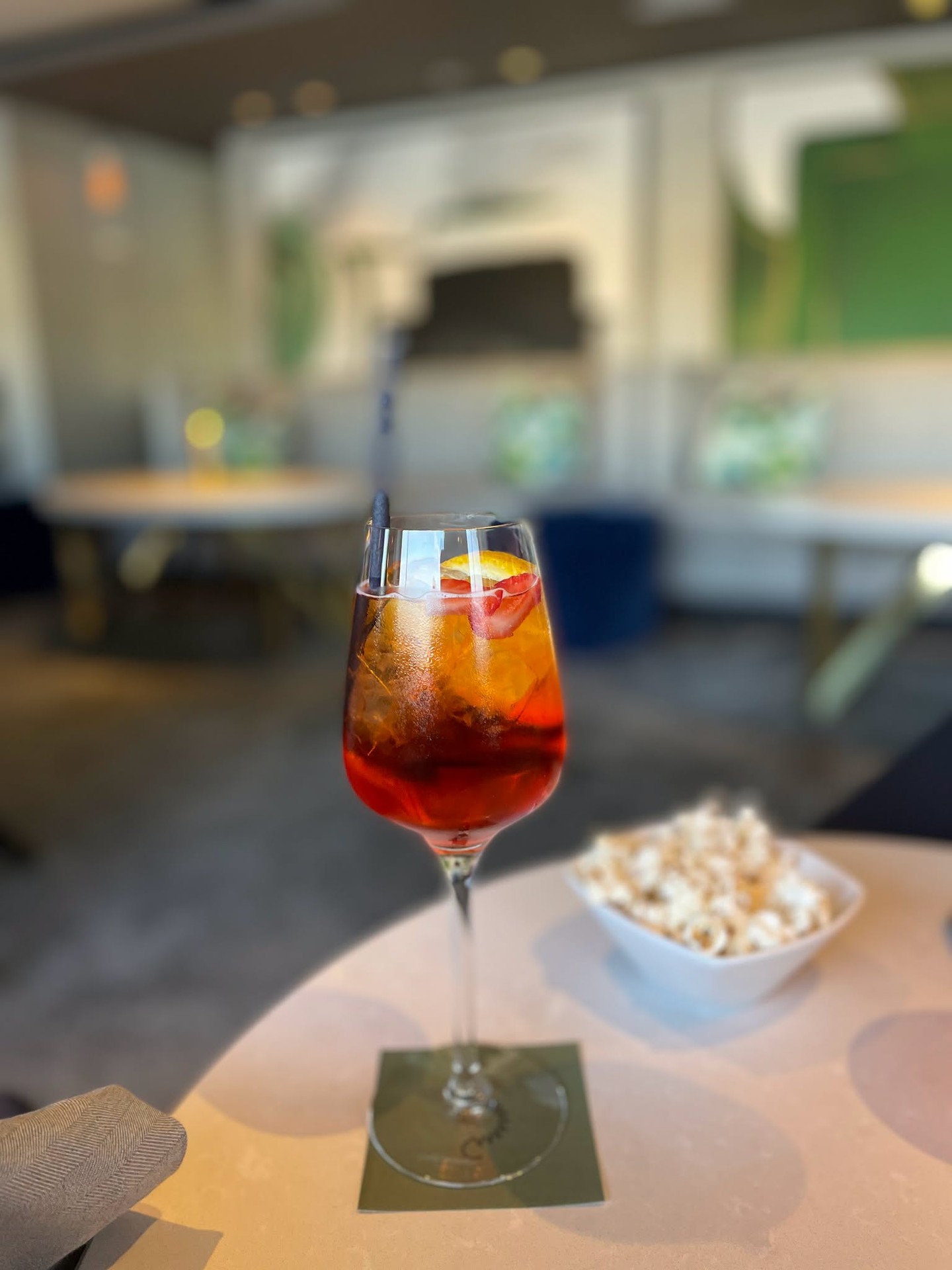 Aperol Spritz cocktail with olive garnish in lounge setting aboard Riverside Luxury Cruises