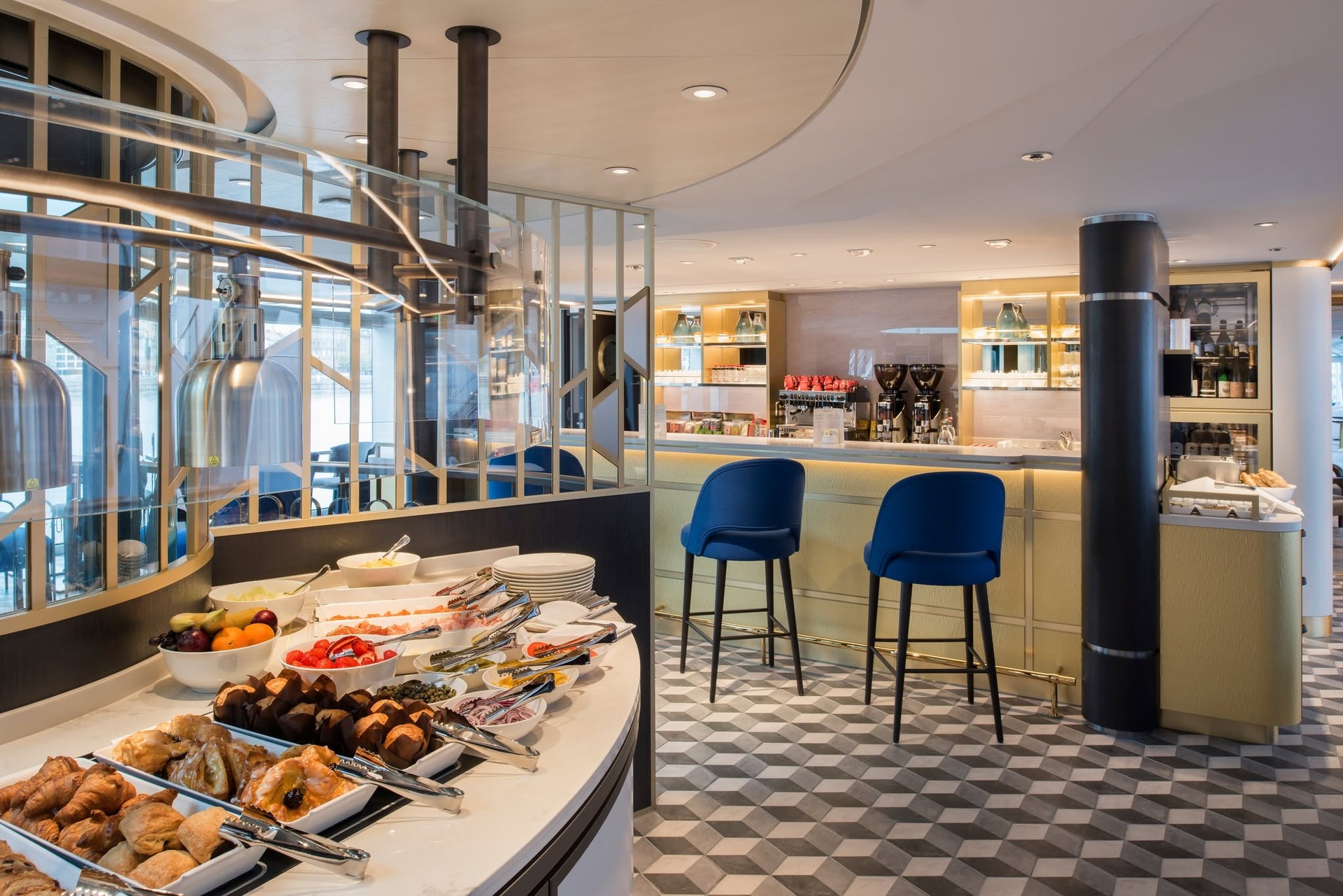 The Bistro marketplace counter with pastries, fresh fruits, and barstools on Riverside Debussy