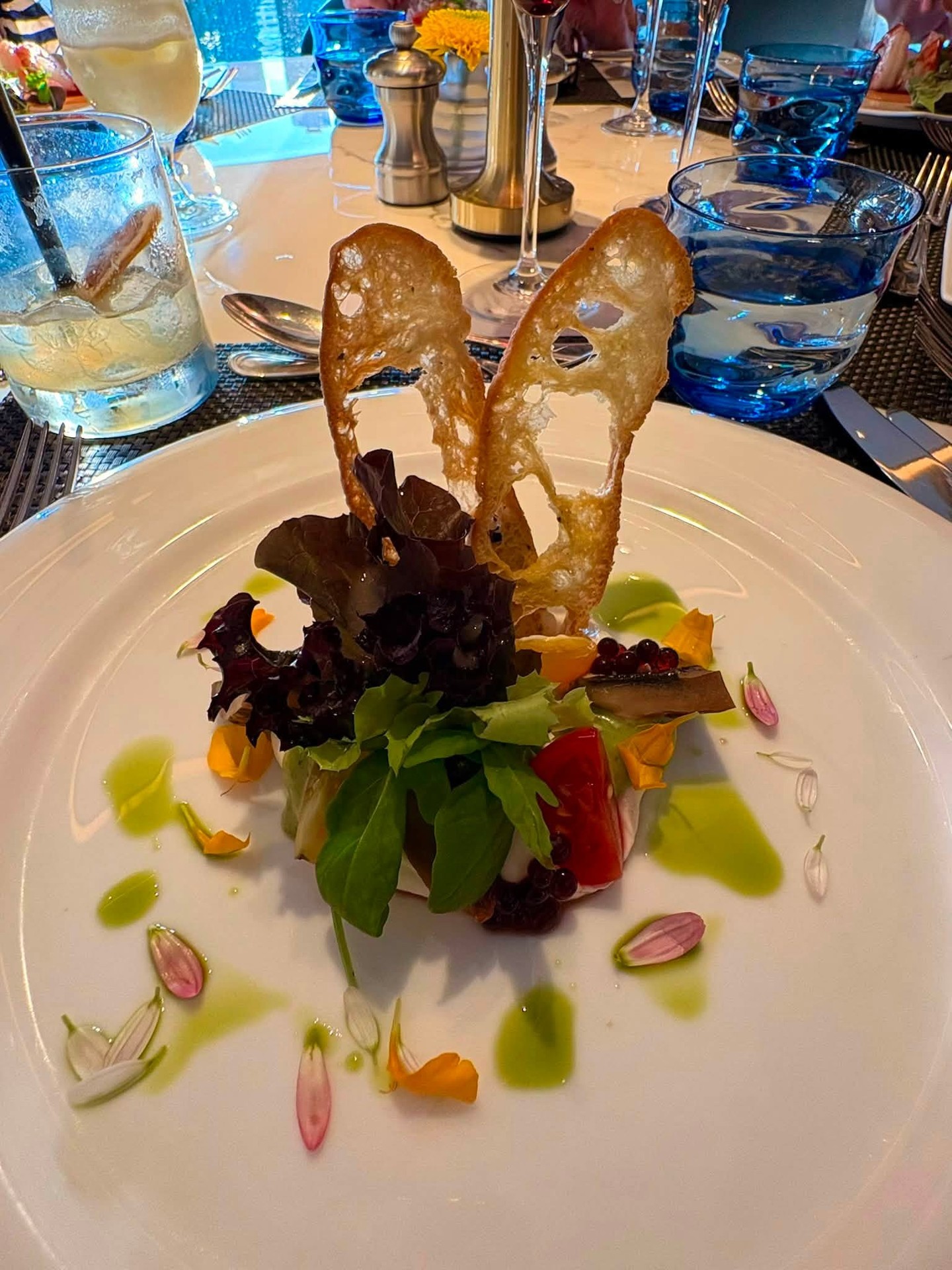 Fine dining plated salad with artistic crispbread and edible flowers on Riverside Luxury Cruises