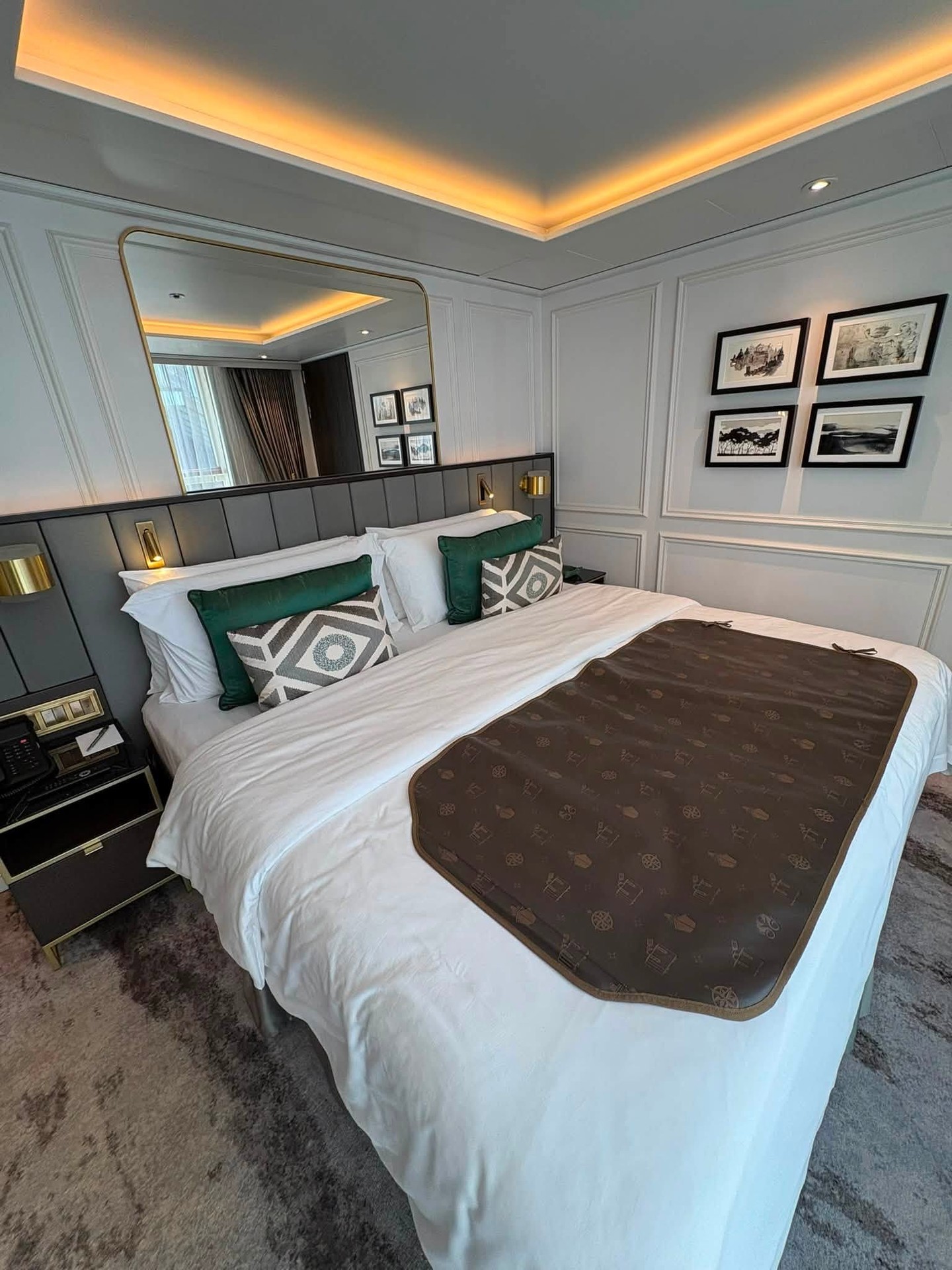 Close-up of plush King bed with luxury European linens and headboard lighting on Riverside Debussy