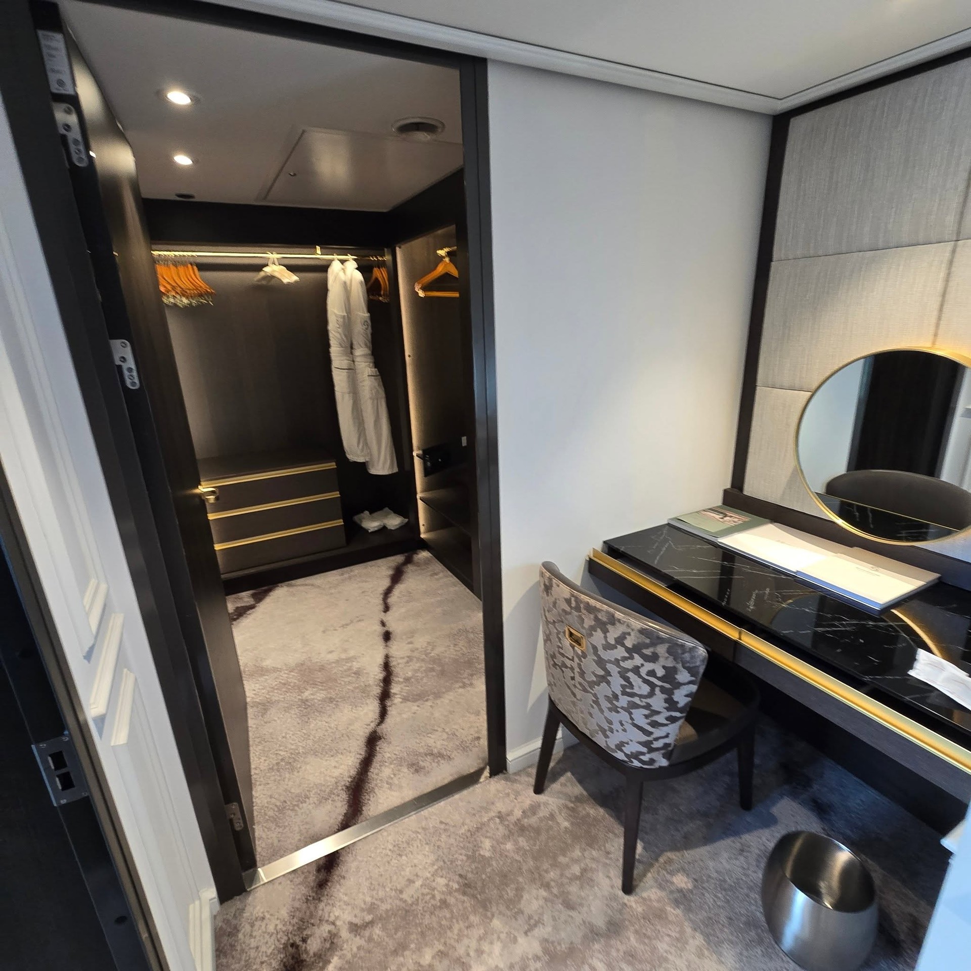 Walk-in dressing room and vanity desk with lighted mirror in suite on Riverside Debussy