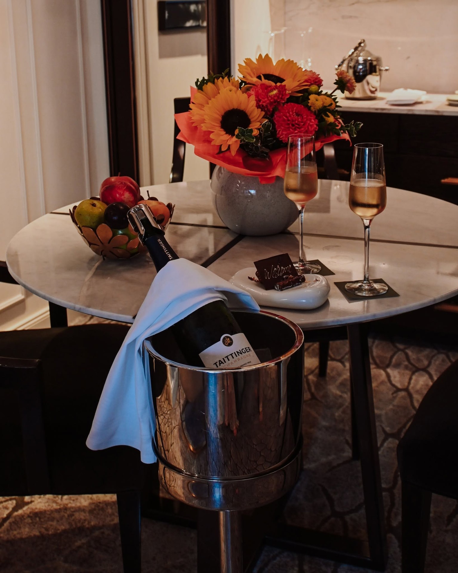Fresh orange and yellow floral arrangement with welcome champagne in suite on Riverside Debussy