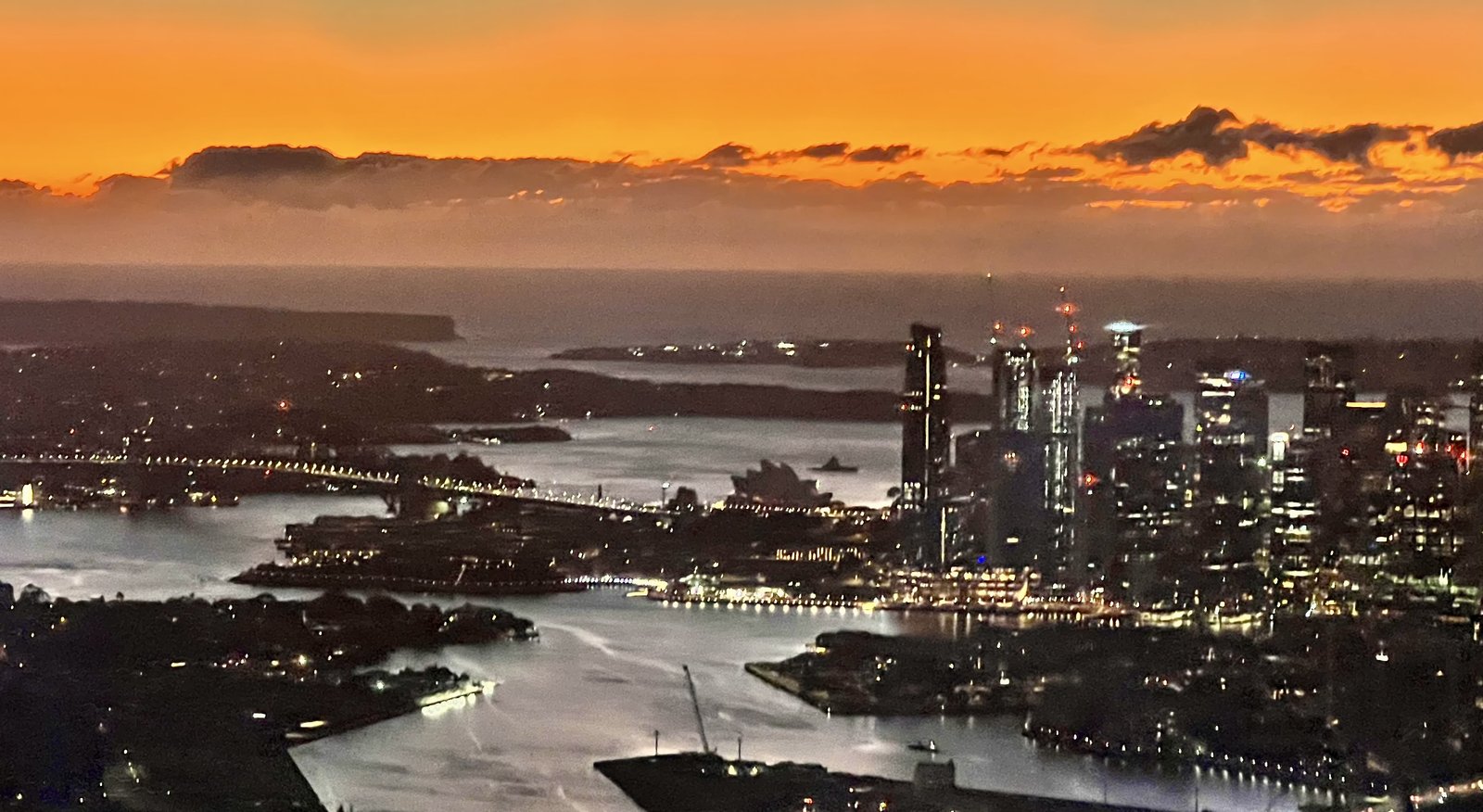Aerial view of Sydney Harbour at sunrise from flight window
