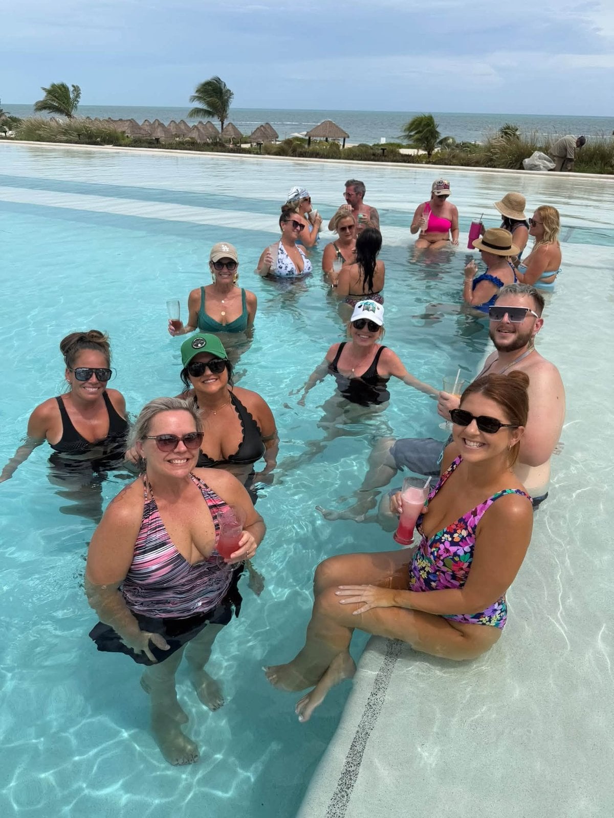 Vincent Vacations advisors toasting in the crystal clear pool at Dreams Playa Mujeres