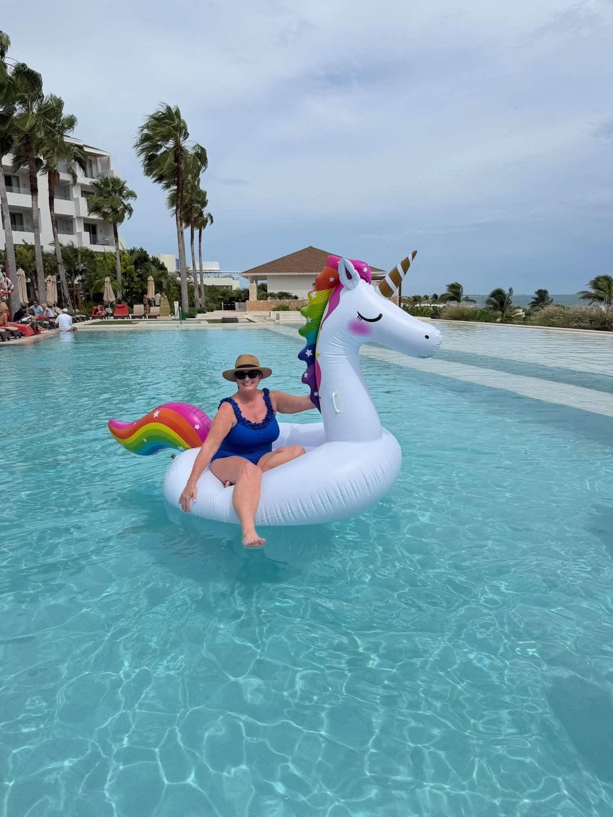 Relaxing on the giant inflatable unicorn in the crystalline resort lagoon pool