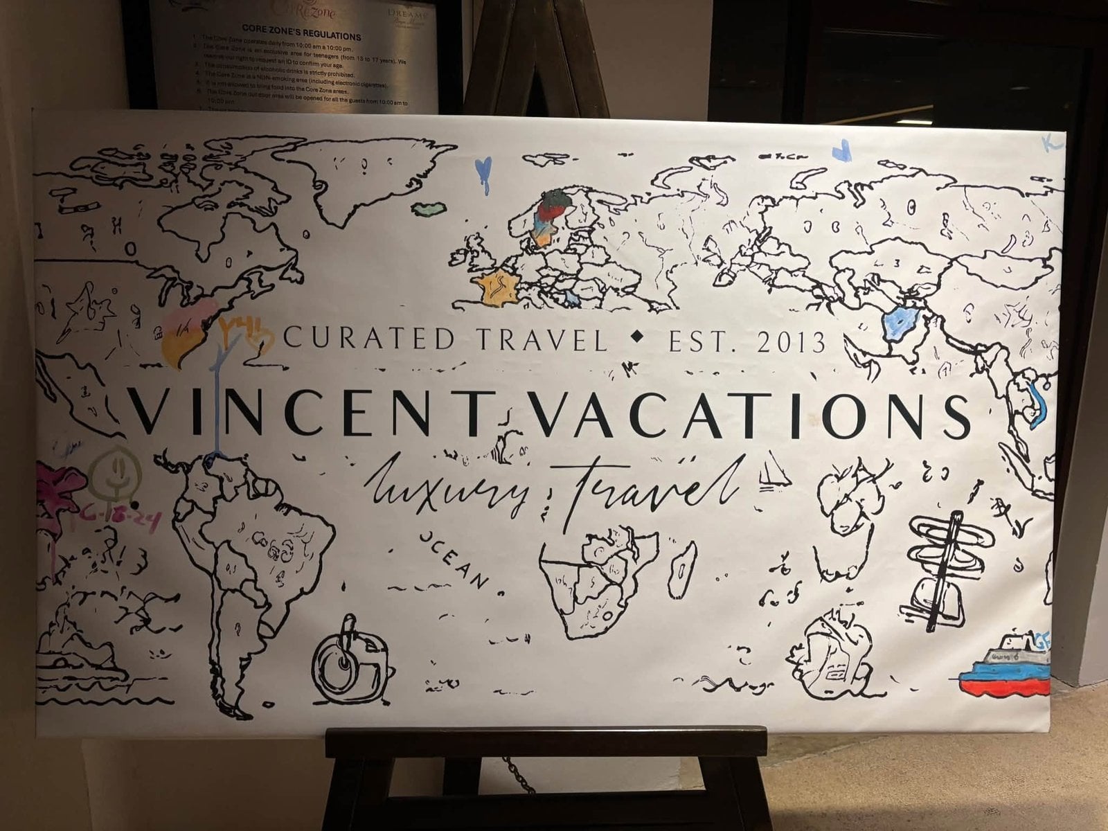 Travel advisor hand-coloring the Vincent Vacations Curated Travel world map commemorative canvas