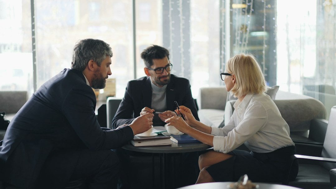 Boutique travel host agency executive collaborating one-on-one with a high-producing luxury travel advisor in a private consultation suite