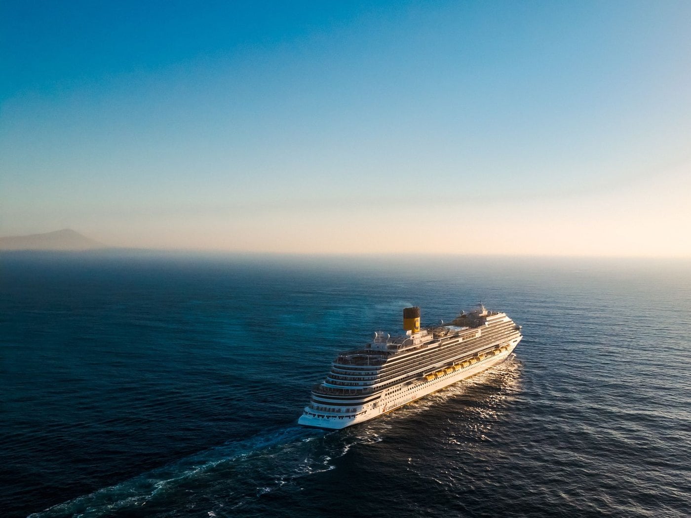 Luxury cruise ship sailing at sunset representing high margin group cruise operations and charter contracts