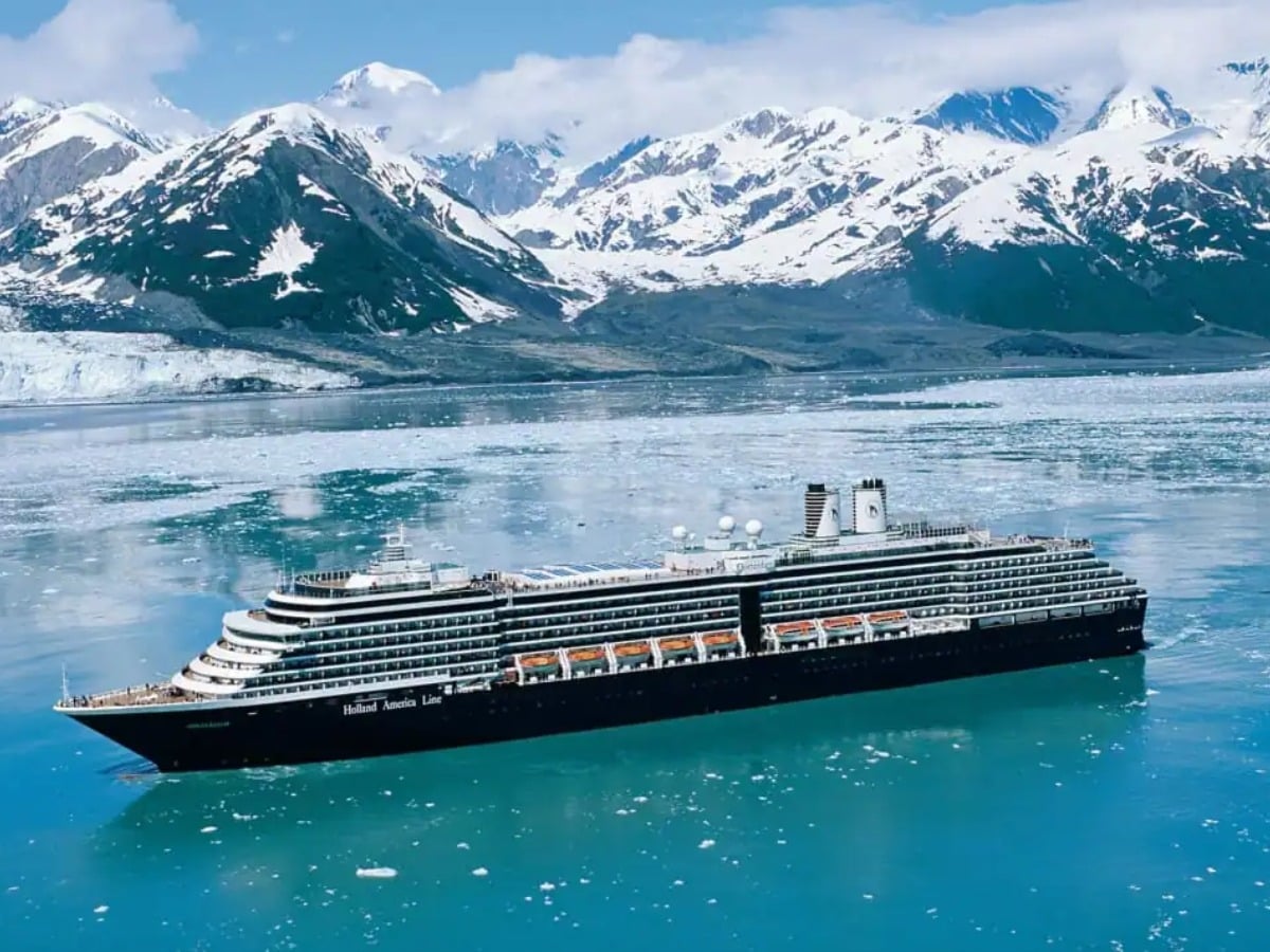 Holland America Line cruise ship cruising majestic glaciers and snow-capped mountains in Alaska