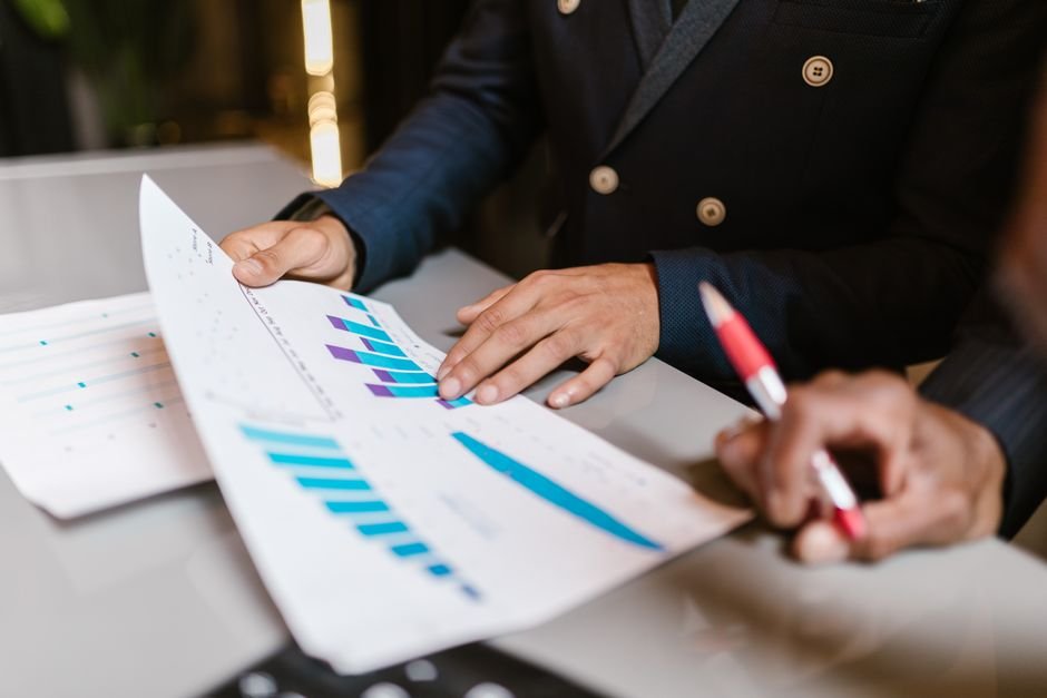 Business executives reviewing host agency comparison analysis, commission splits, and contract terms