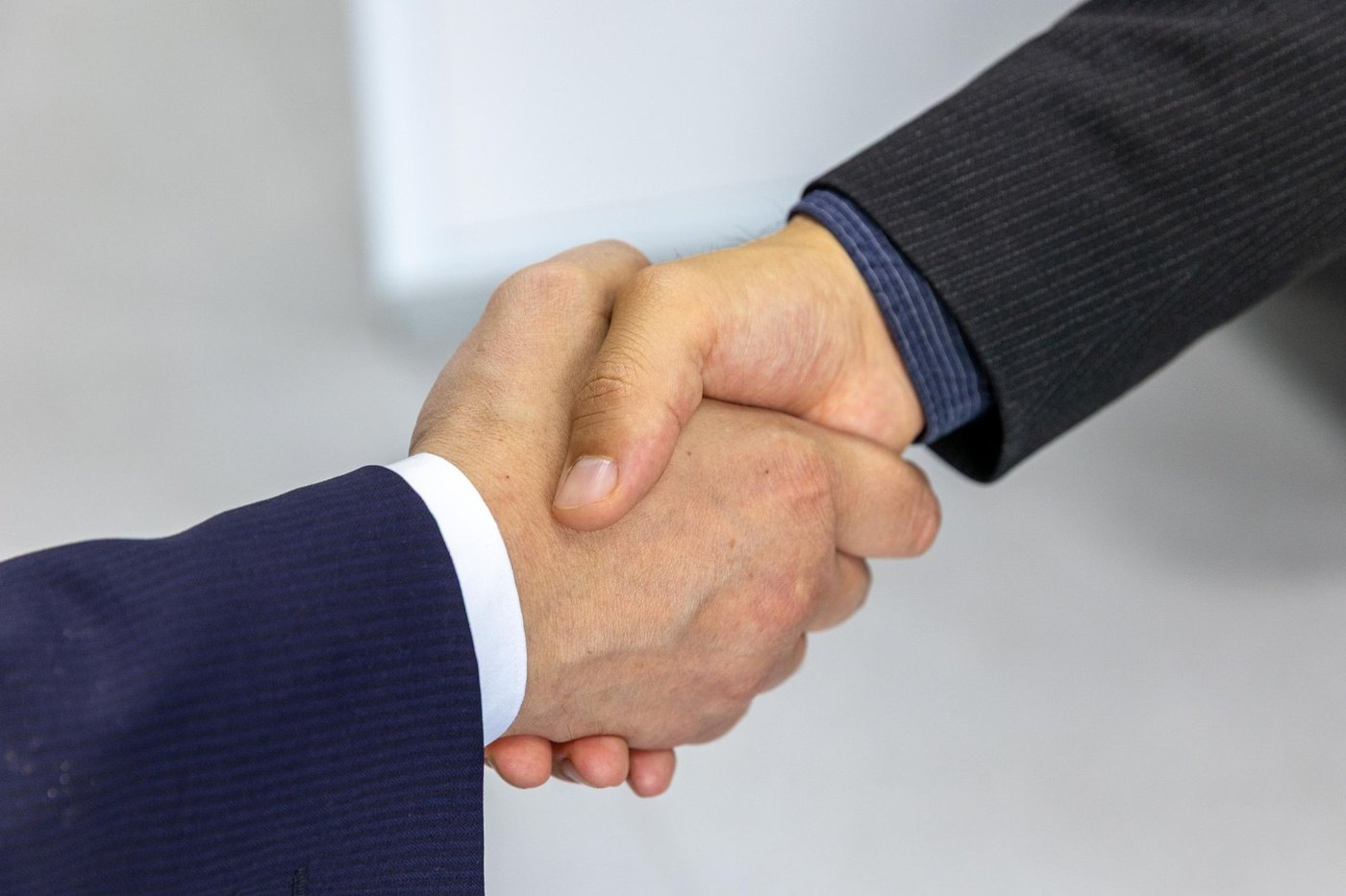 Travel agency owner and host executive shaking hands on a transparent, advisor-first contract partnership