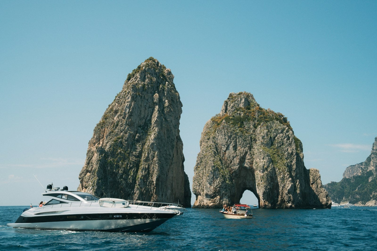 Private Riva yacht charter cruising past Faraglioni rocks in Capri