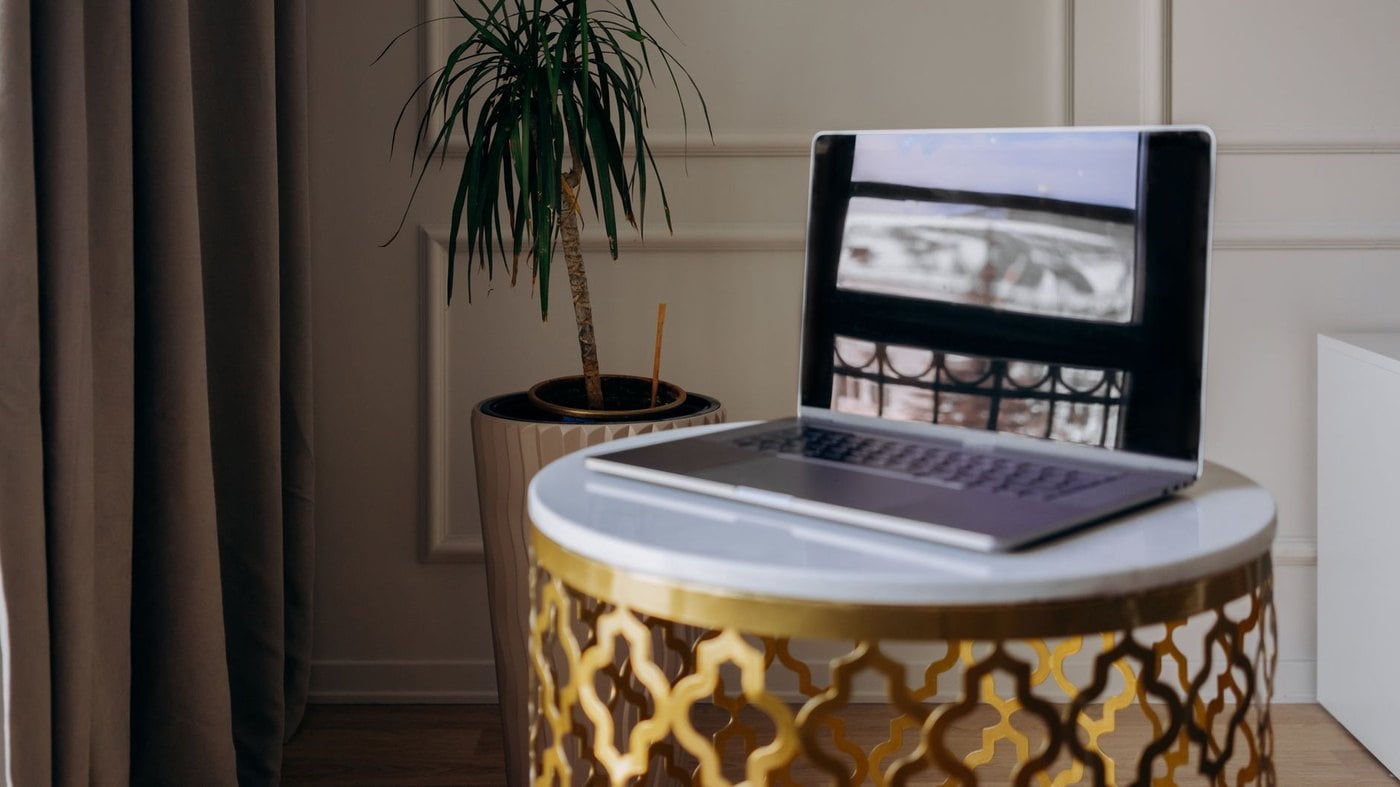 Executive luxury travel advisor desk workspace with dual monitors, travel itineraries, and business planning resources