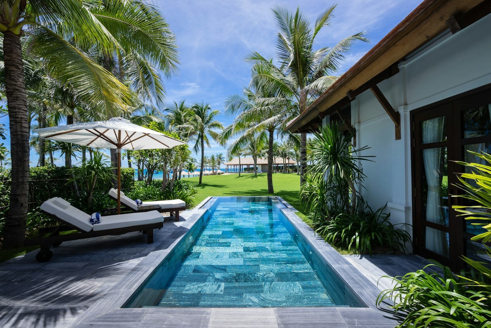 Multi-generational family gathering outside private beachfront luxury resort villas
