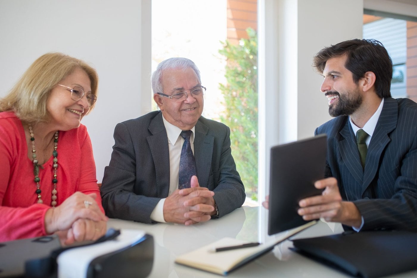 Affluent couple enthusiastically approving travel planning agreement and retainer fee with their advisor
