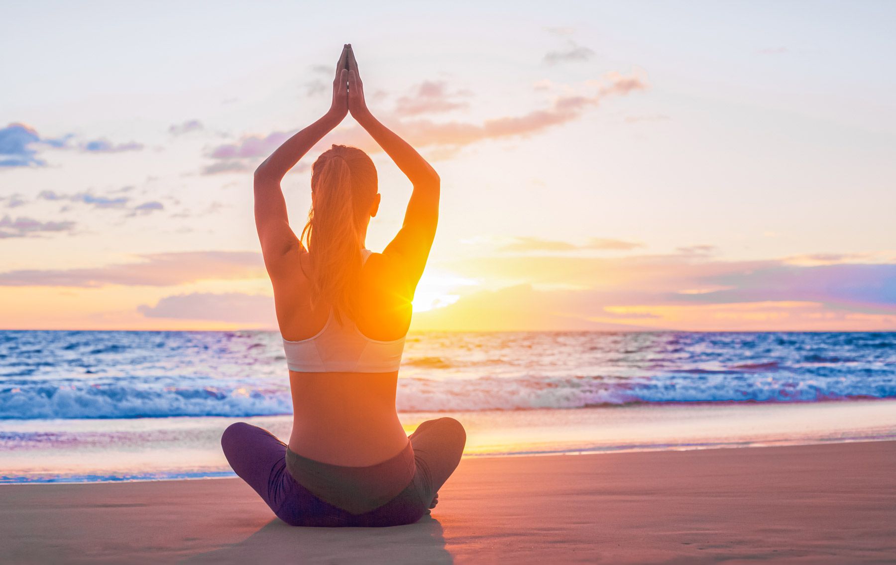 woman practicing yoga seashore