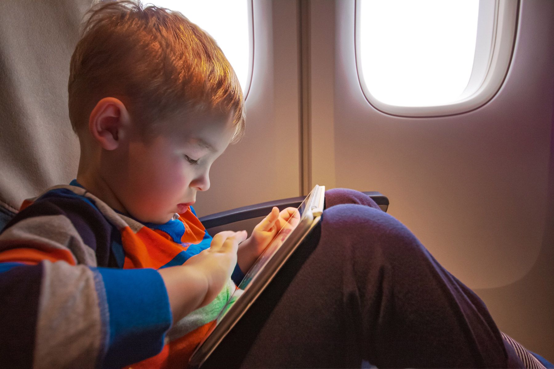 child with tablet plane