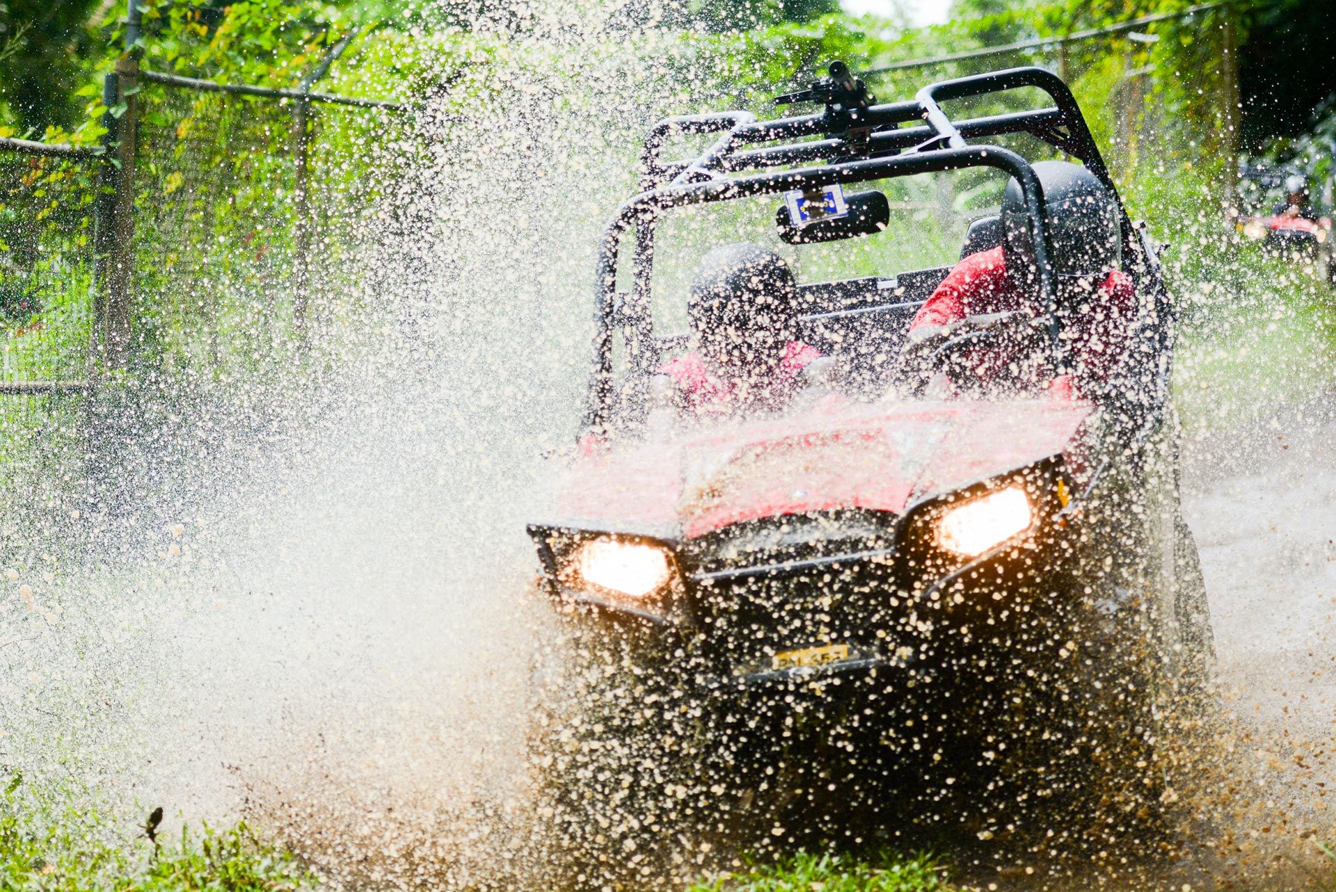 dune buggy plowing through puddle splashing water all over