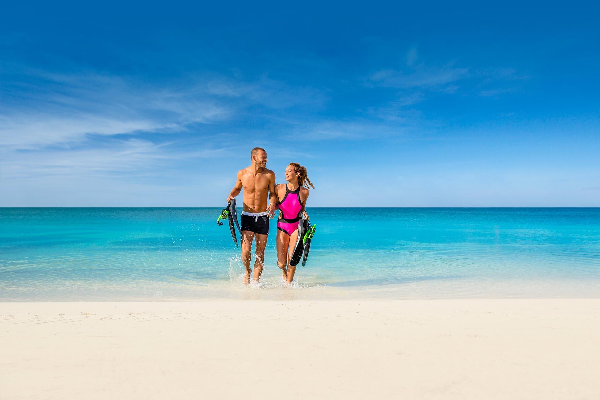 couple with snorkeling equipment on the beach