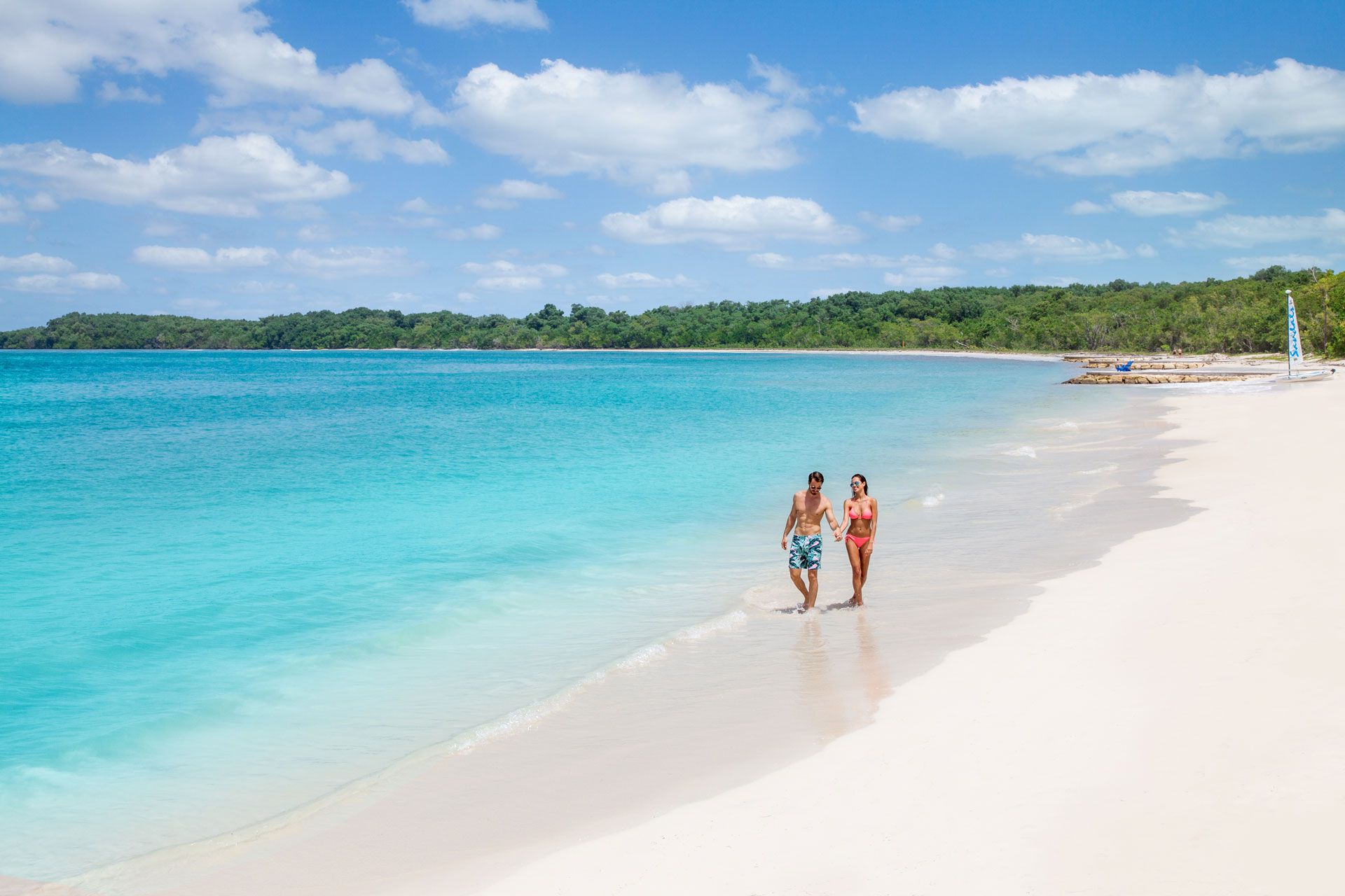 Couple walking down Jamaican beach