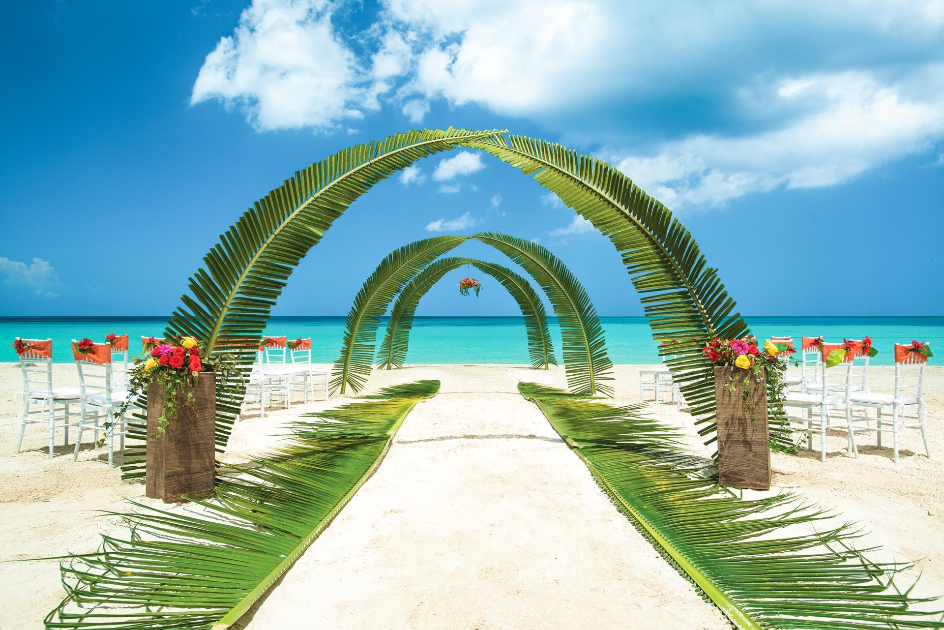 Beach wedding ceremony with palm leaves