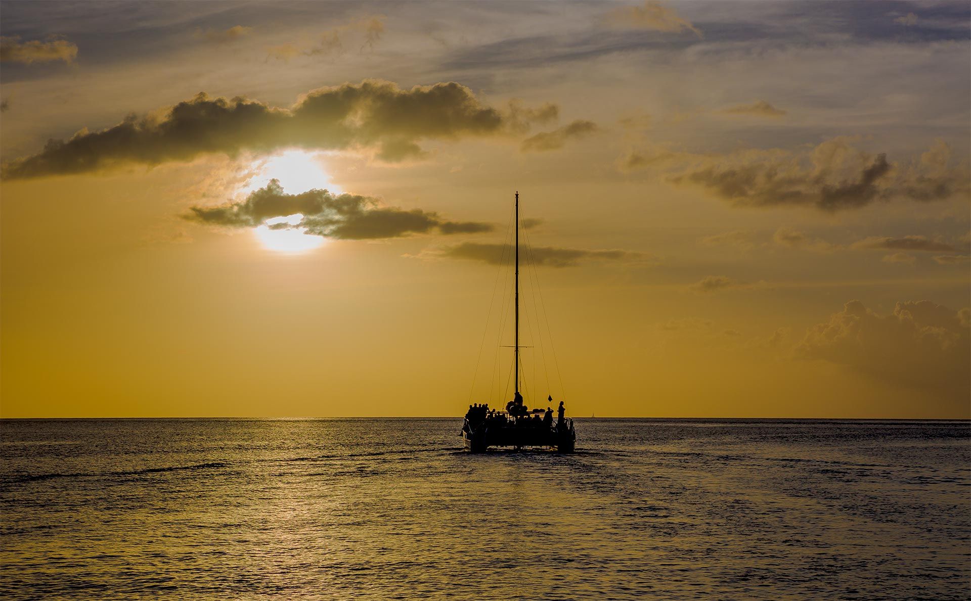 sunset cruise making it's way through golden sea