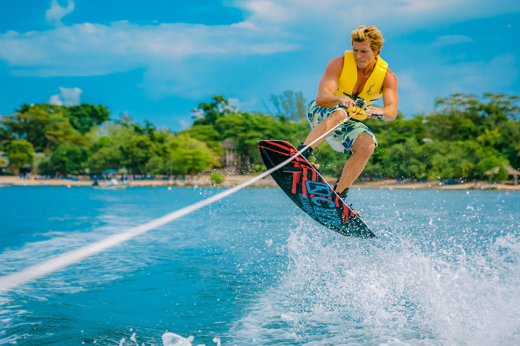 young man wakeboarding and jumping wave