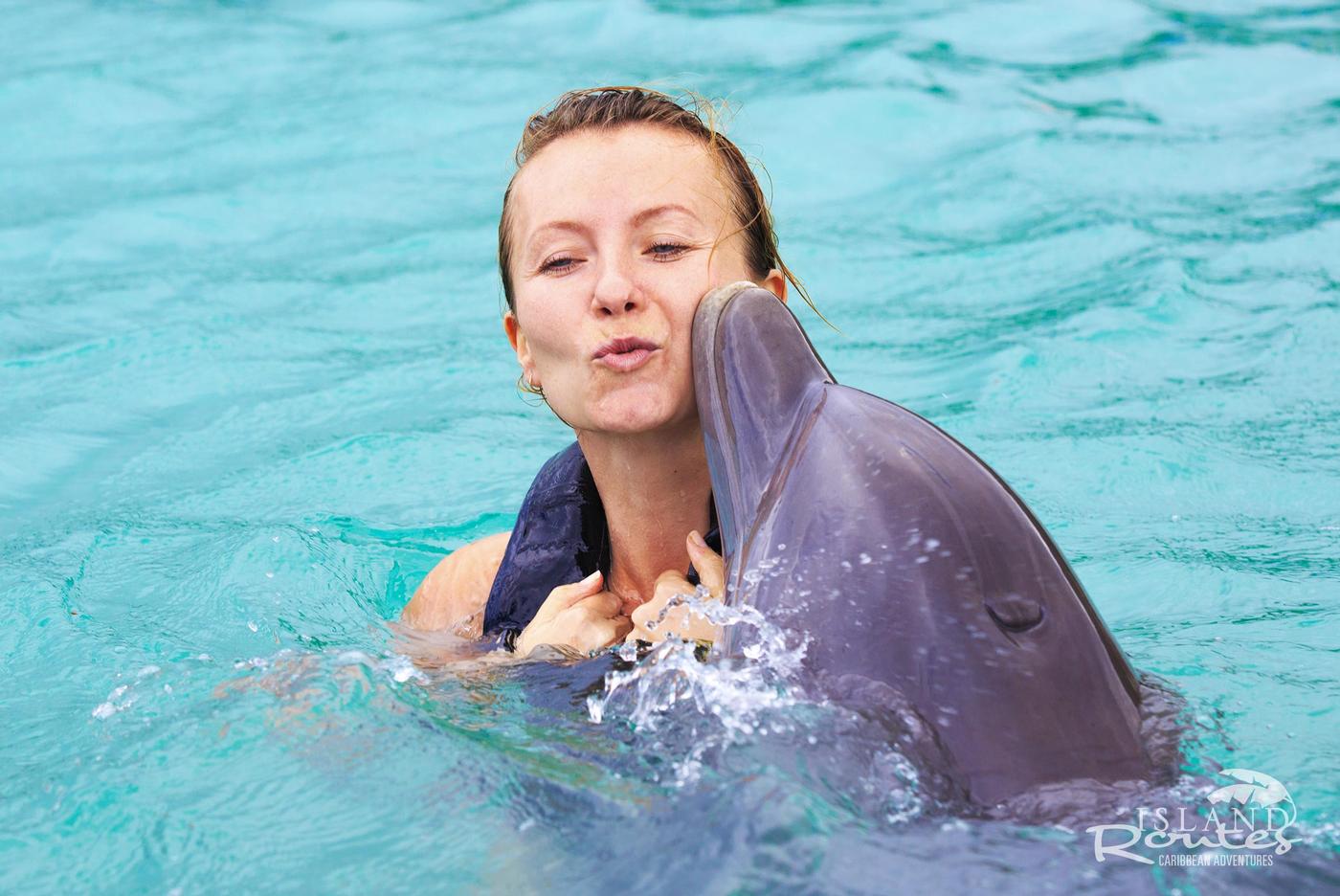 woman being kissed by dolphin
