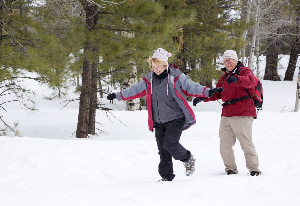 older couple playing in the snow in aspen