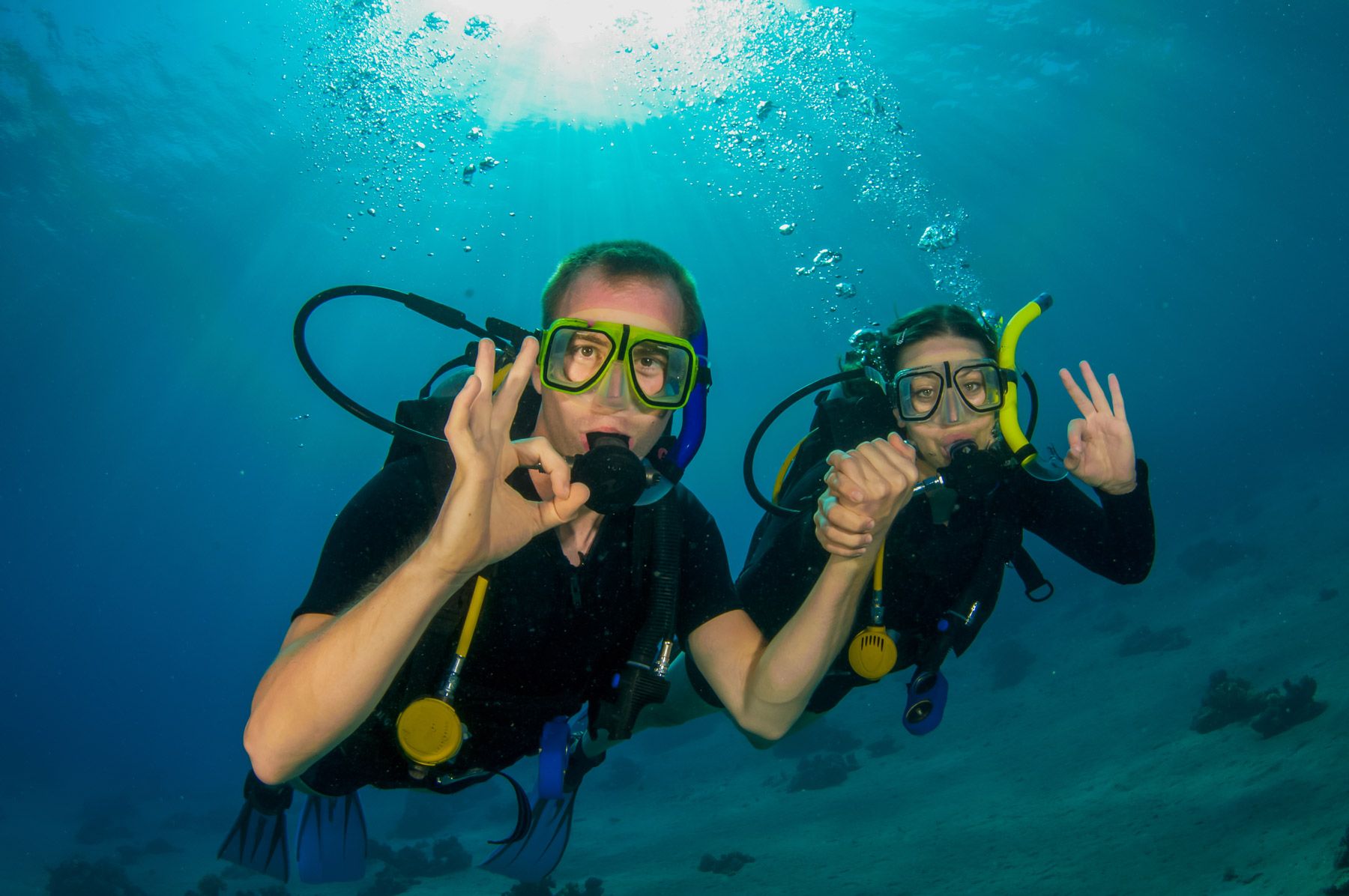 couple scuba diving giving the OK signal
